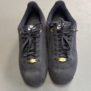 NWOB (never worn)Nike Ladies Black Suede Low-Profile Sneakers with Gold Accents